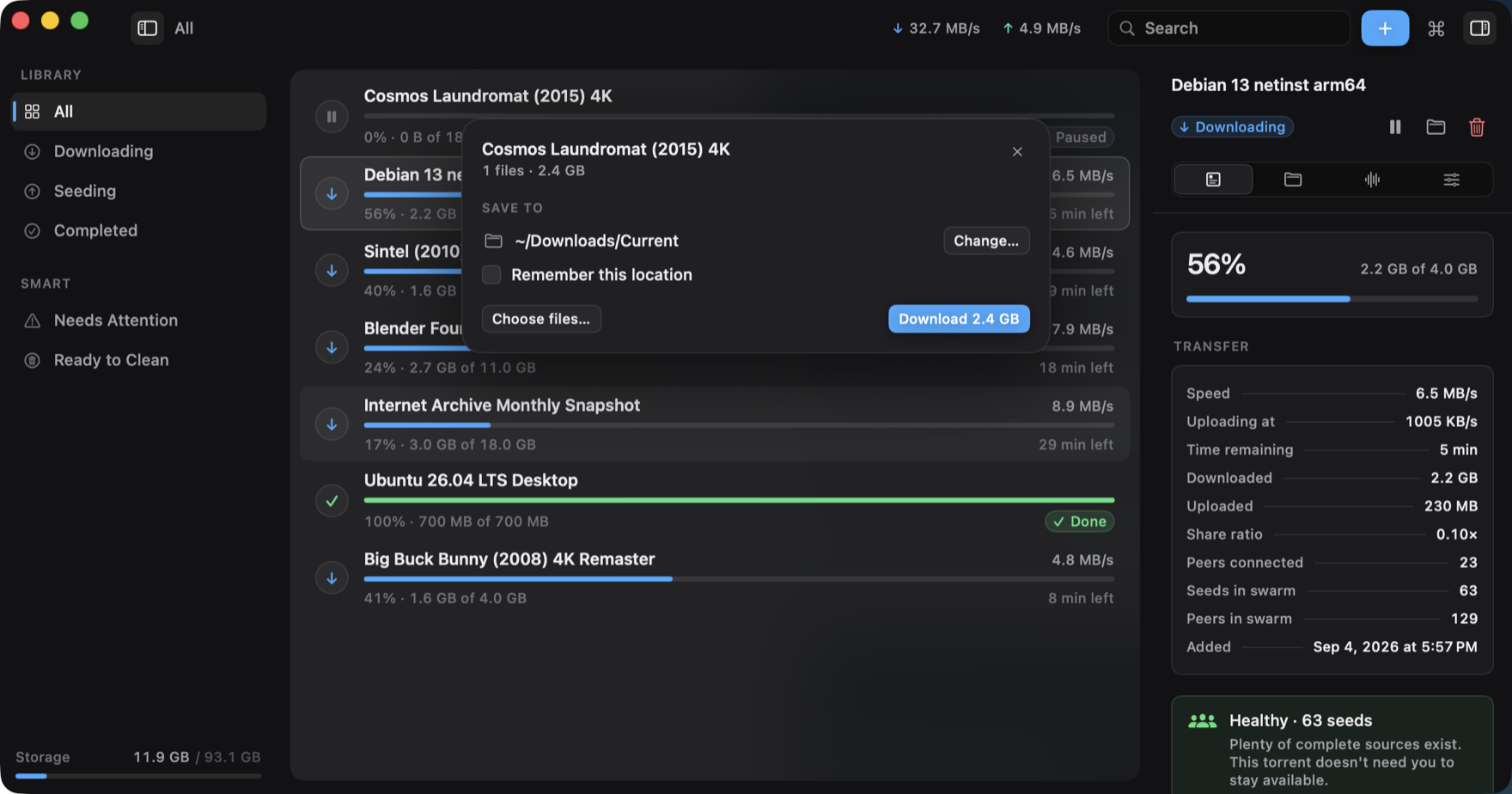 A card over the library reading Cosmos Laundromat (2015) 4K, 1 files, 2.4 GB, with a save location of ~/Downloads/Current, a Change button, a Remember this location checkbox, and a blue Download 2.4 GB button.